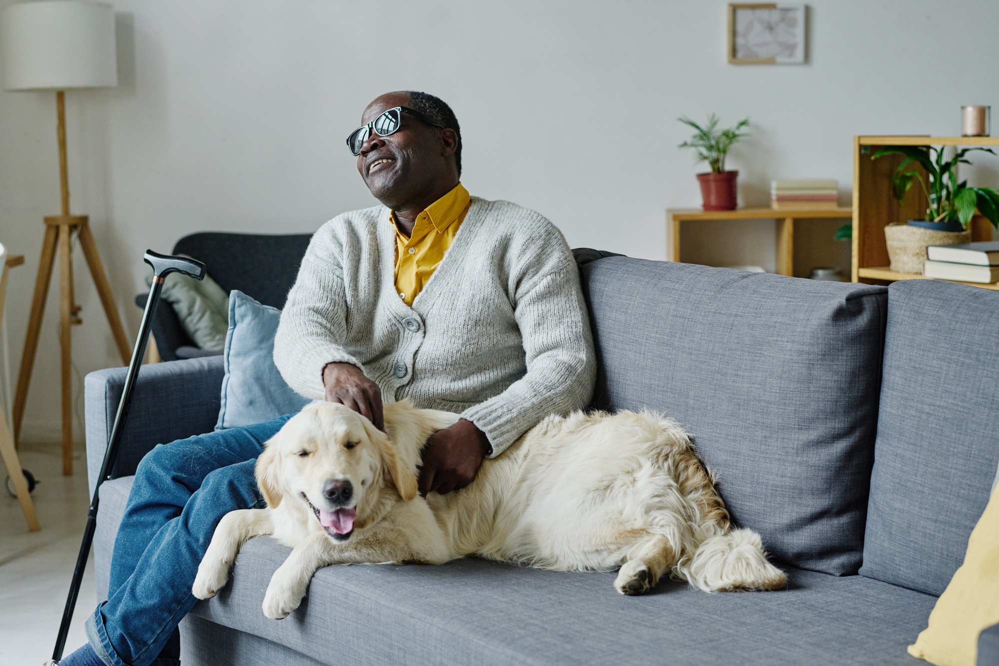 Homme aveugle avec chien guide à la maison